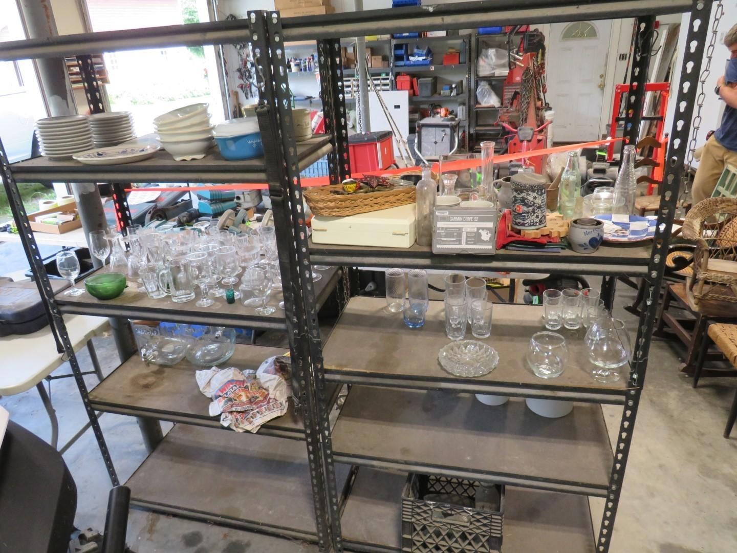 Metal shelving unit filled with dishes, glassware, and household items.