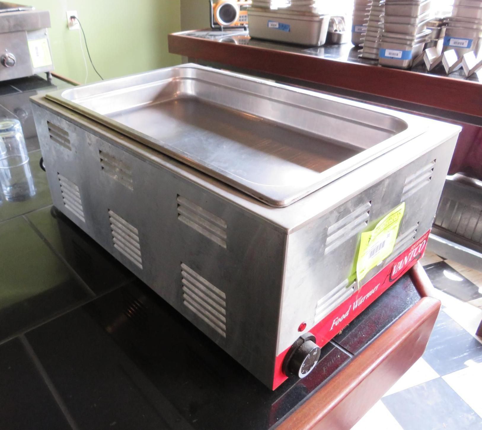 Stainless steel food warmer with temperature dial on a counter.