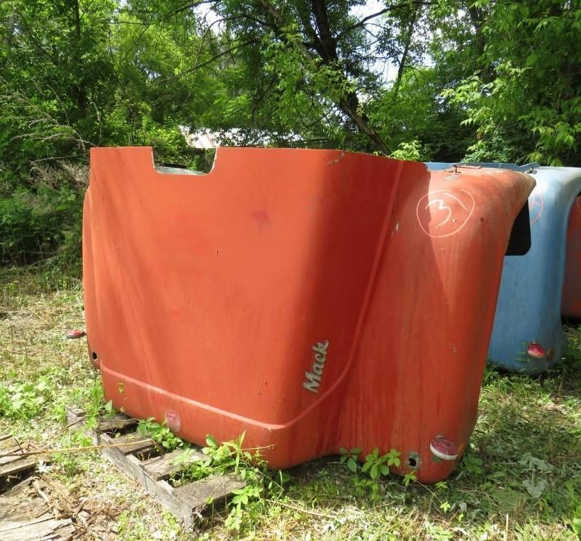 Orange Mack truck hood, outdoors on a pallet, with the name