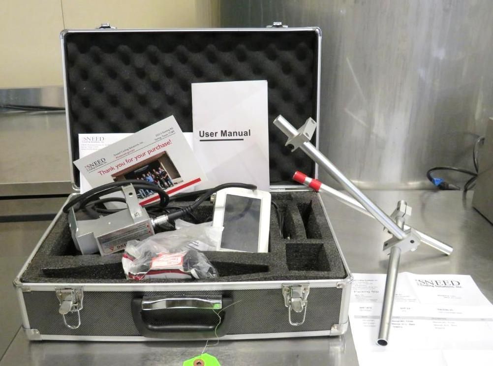 Silver case with equipment and user manuals. Includes a stand and handheld device.