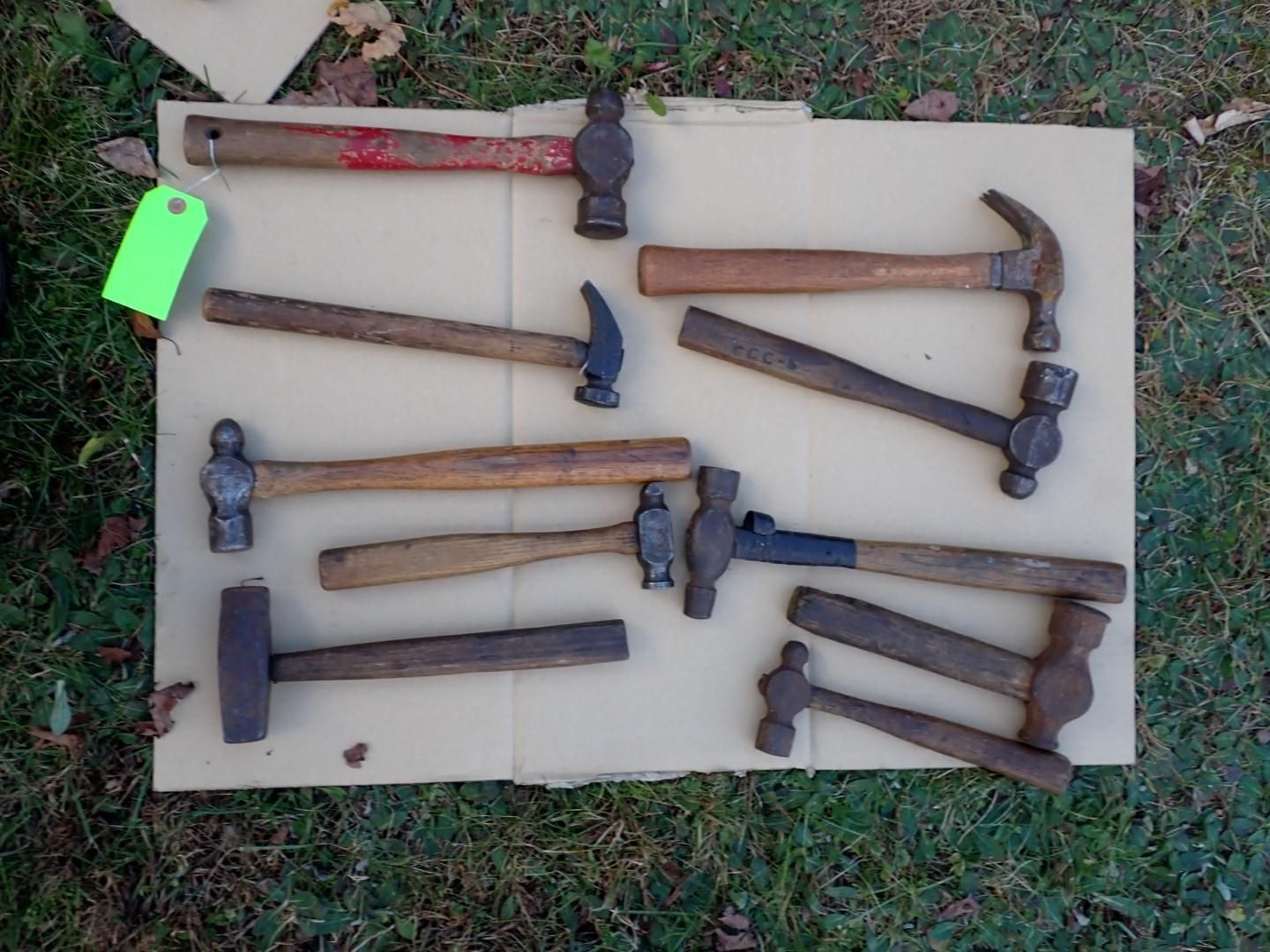 Nine hammers of various sizes and styles displayed on cardboard.