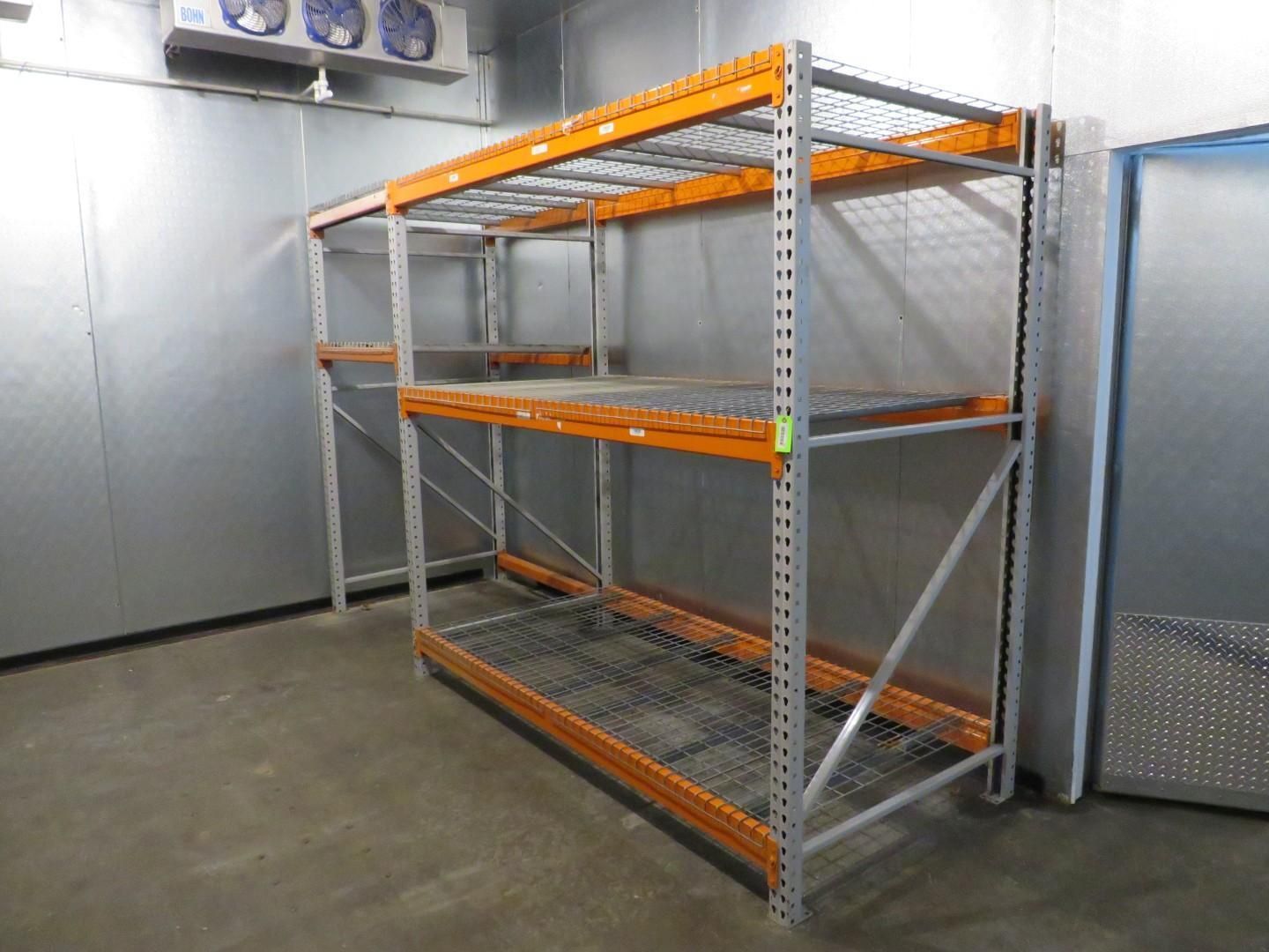 Metal storage racks in a cold storage room; orange shelves and gray metal frame.