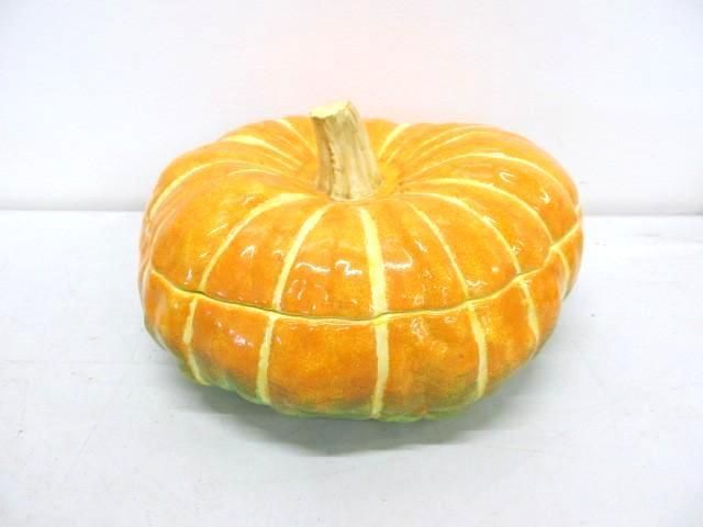 Orange pumpkin with vertical light yellow stripes, a green base, and a brown stem.