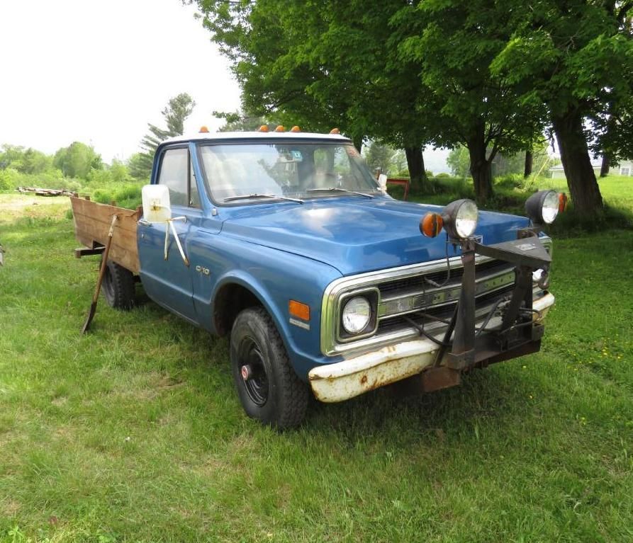 Blue vintage Chevy pickup truck with a flatbed in a grassy field.