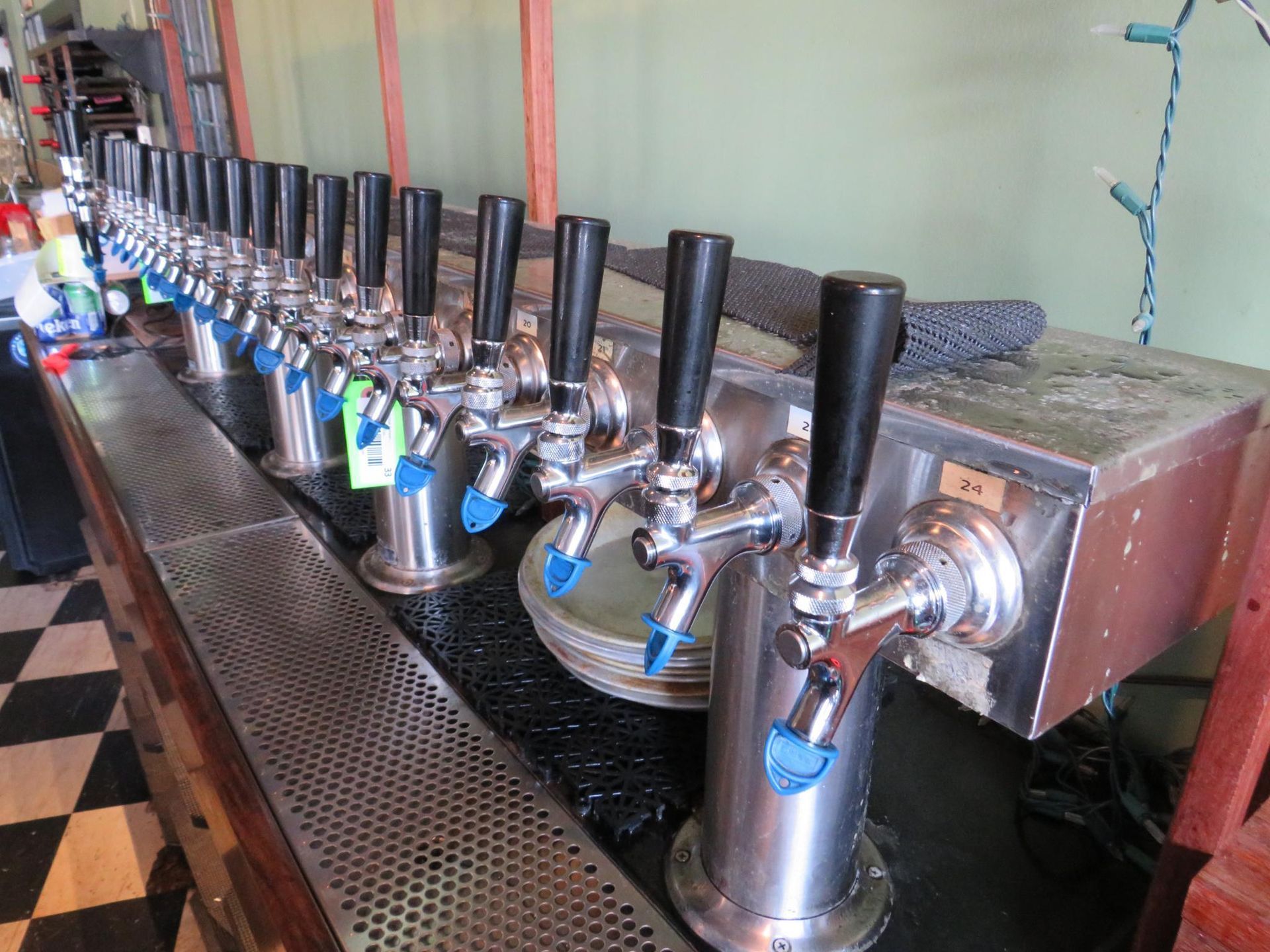 Row of beer taps at a bar, with black handles and silver spouts.