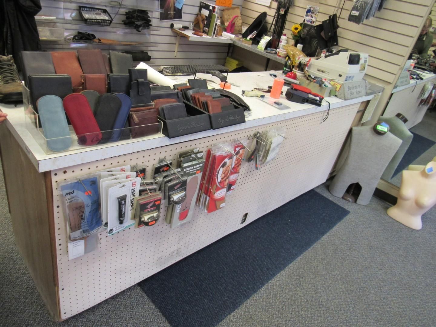 Counter in a store, displaying wallets, phone cases, and other accessories.