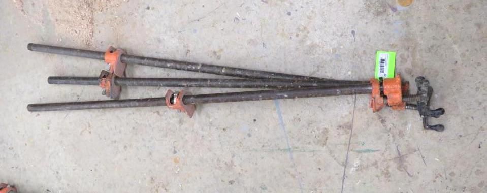 Three pipe clamps on a concrete surface.