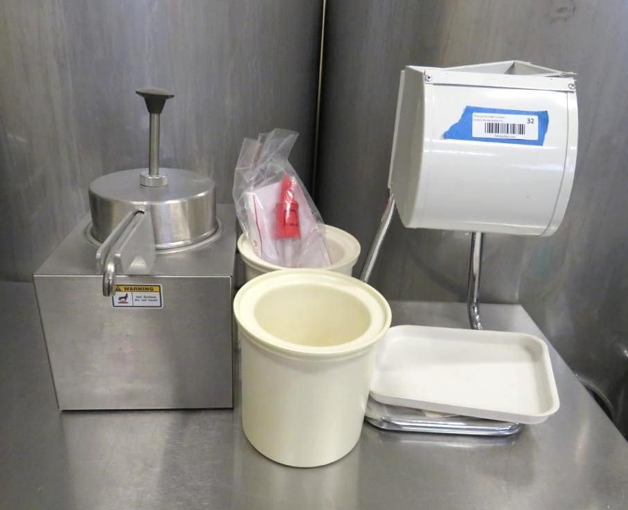 Stainless steel food preparation equipment on a metal surface, including a meat press and containers.