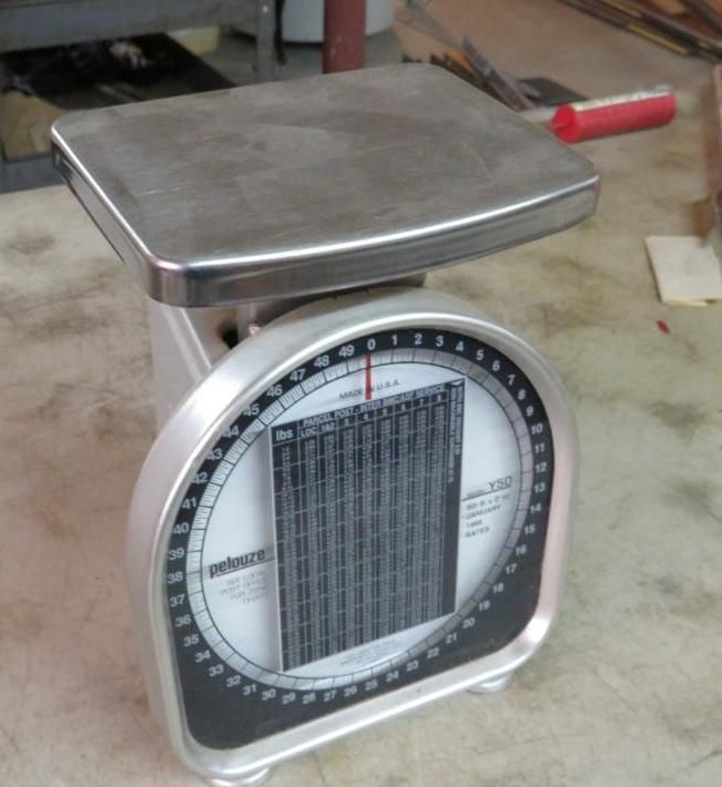 Silver and black mechanical scale with a circular dial and rectangular platform.