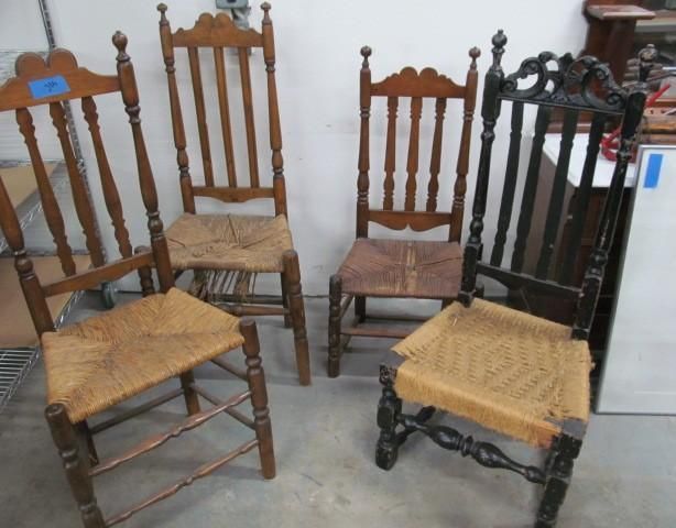 Four antique wooden chairs with straw seats of varying colors.