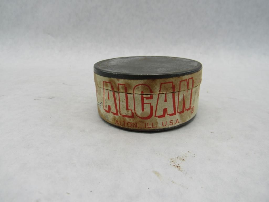 Round metal container labeled