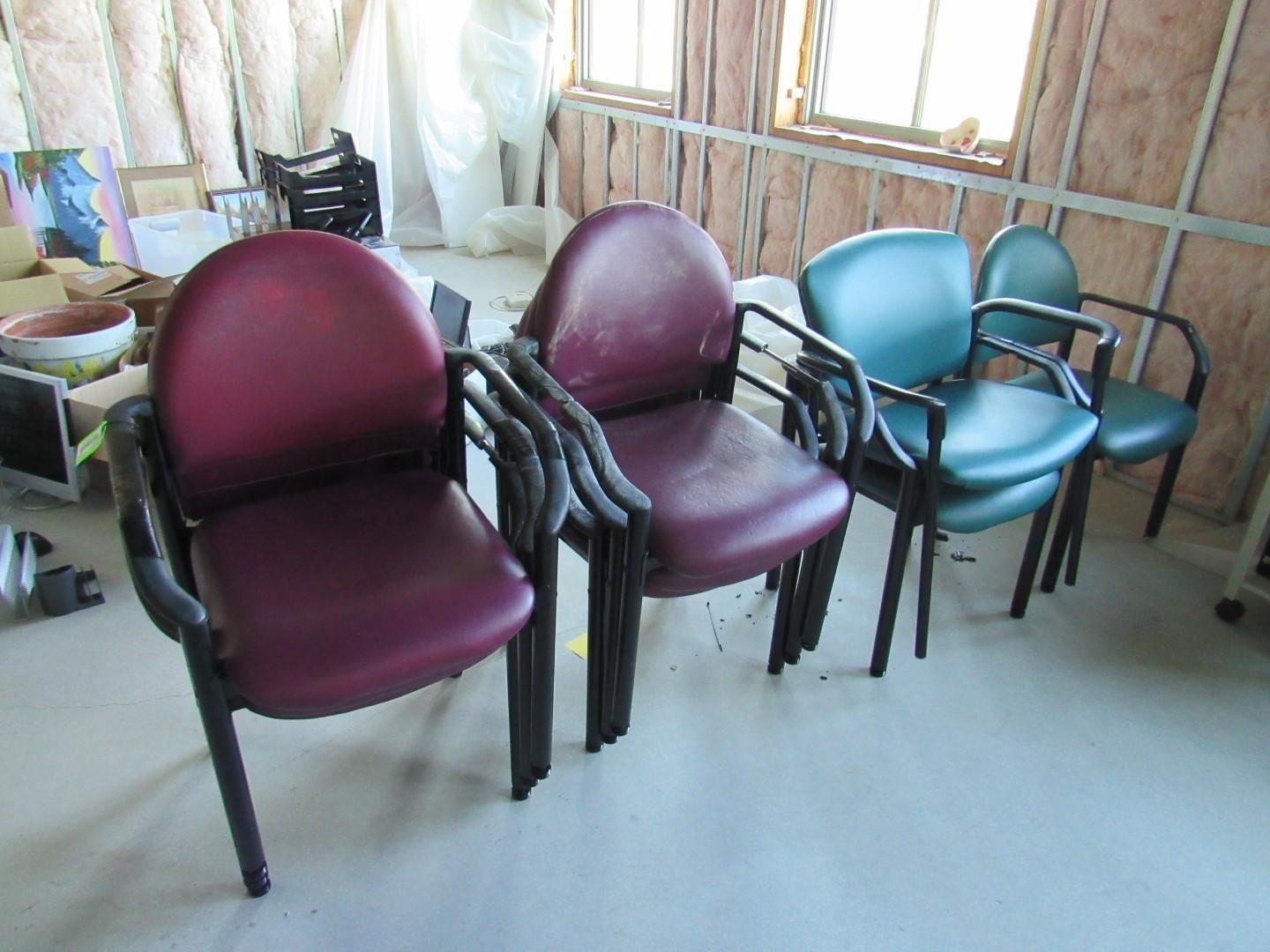 Four office chairs: two burgundy, two teal, all with black arms and legs, in a room.