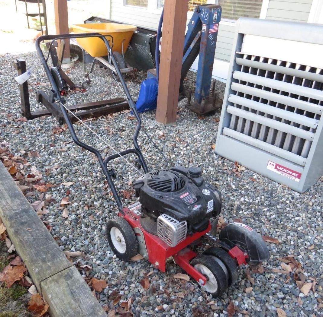 Red lawn edger on gravel surface.