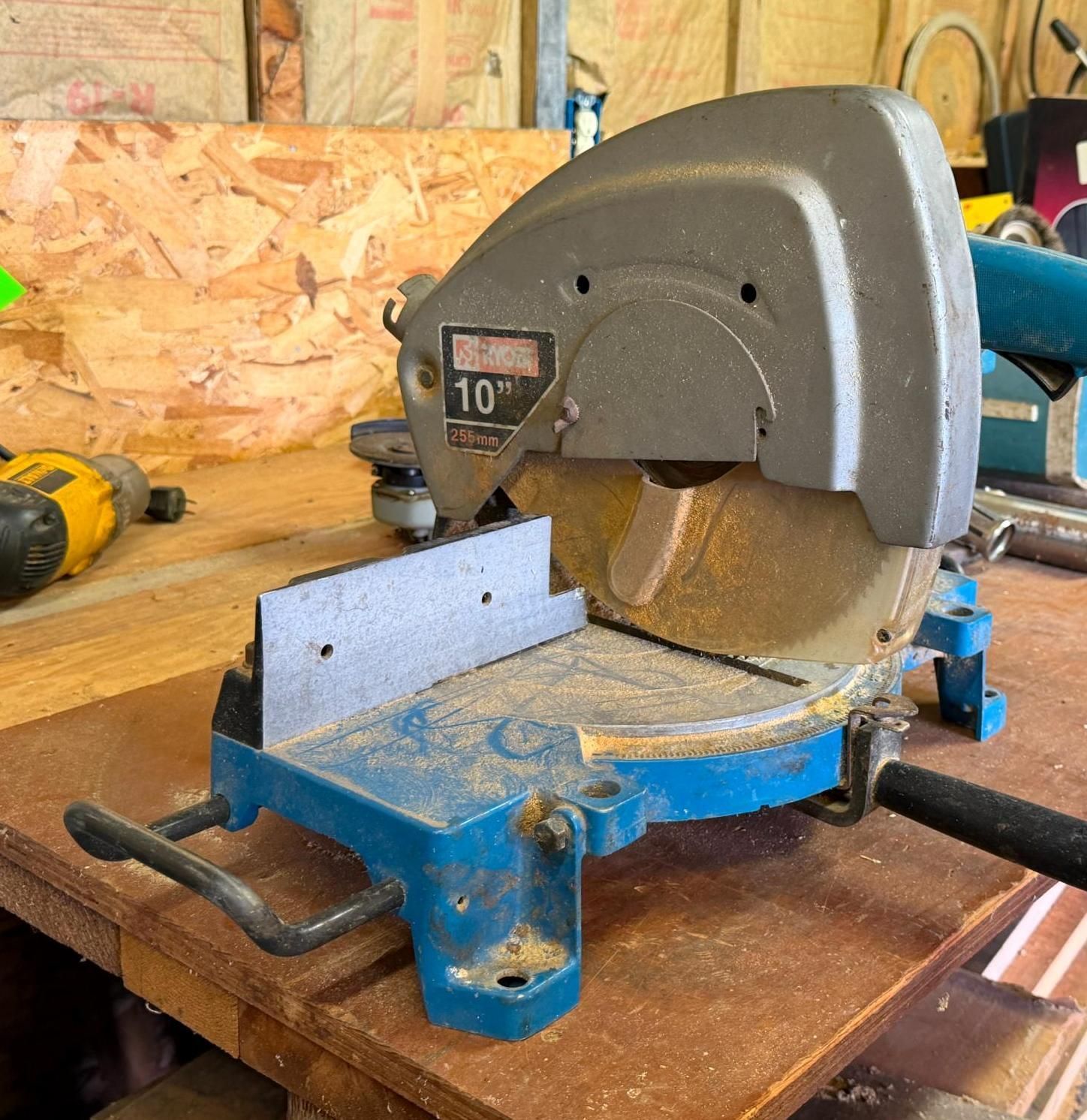 Blue miter saw on a workbench in a woodshop
