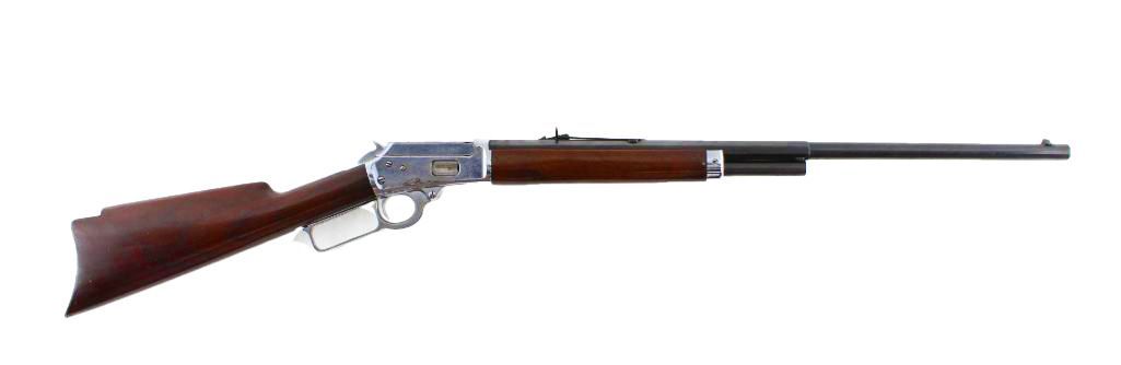 A lever-action rifle, likely a Winchester, with a dark wooden stock and a silver receiver.