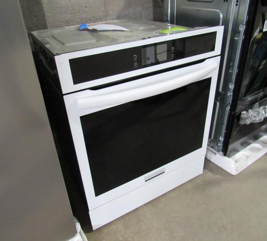 White built-in oven with black door and digital controls, indoors next to other appliances.