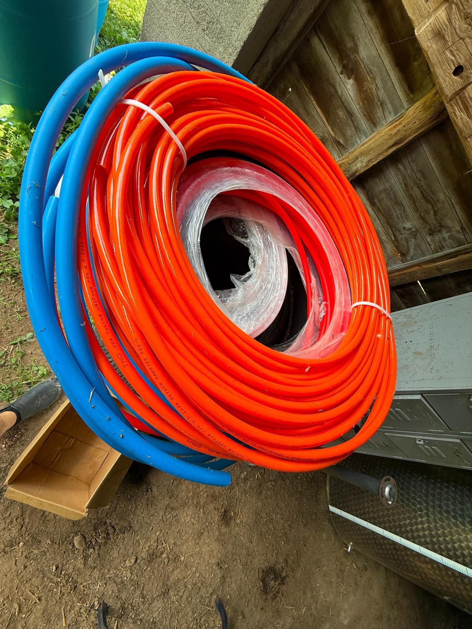 Coiled blue and orange tubing, possibly PEX pipe, bundled together.