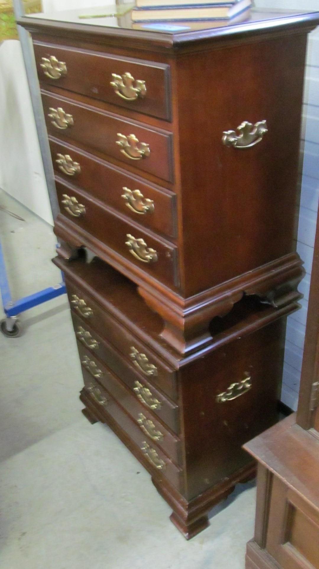 Two wooden chests of drawers stacked together, with multiple drawers and gold-colored handles.