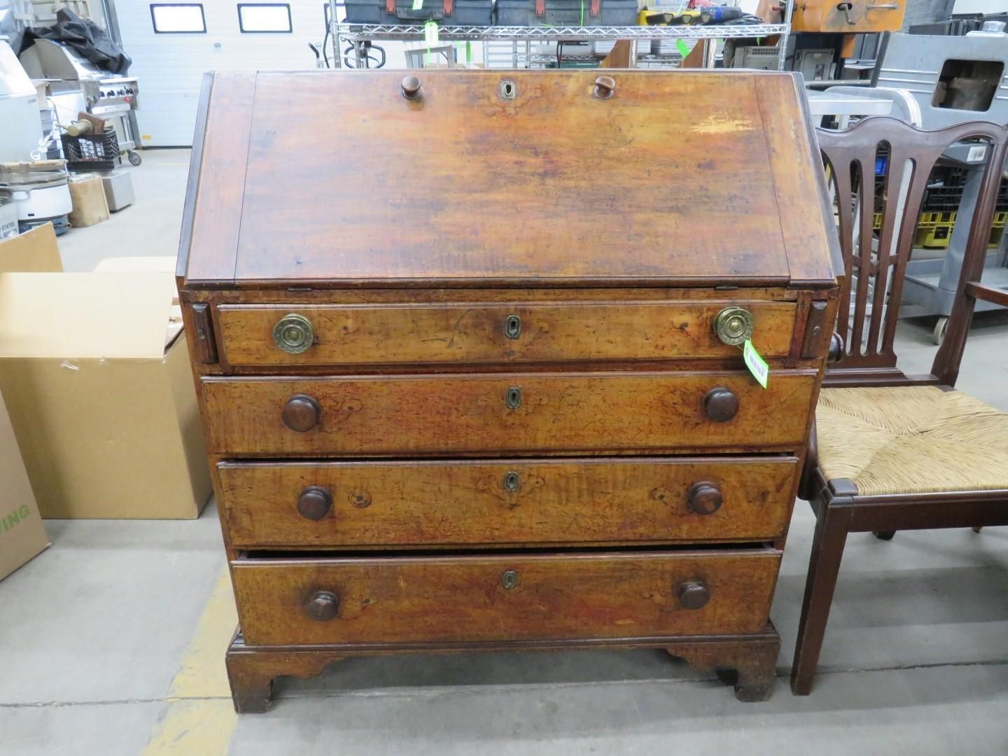 Wooden antique desk with slant top and drawers.