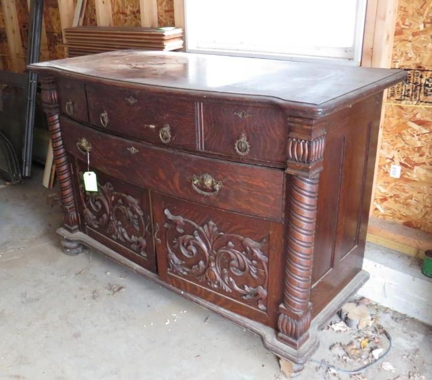 Brown antique wooden dresser with drawers and carved doors.