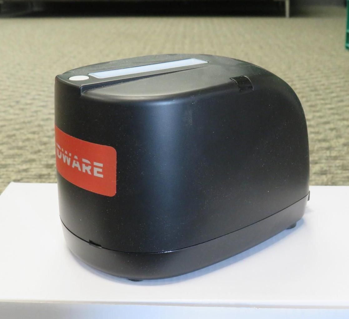 Black and red label printer on a white surface, indoors.