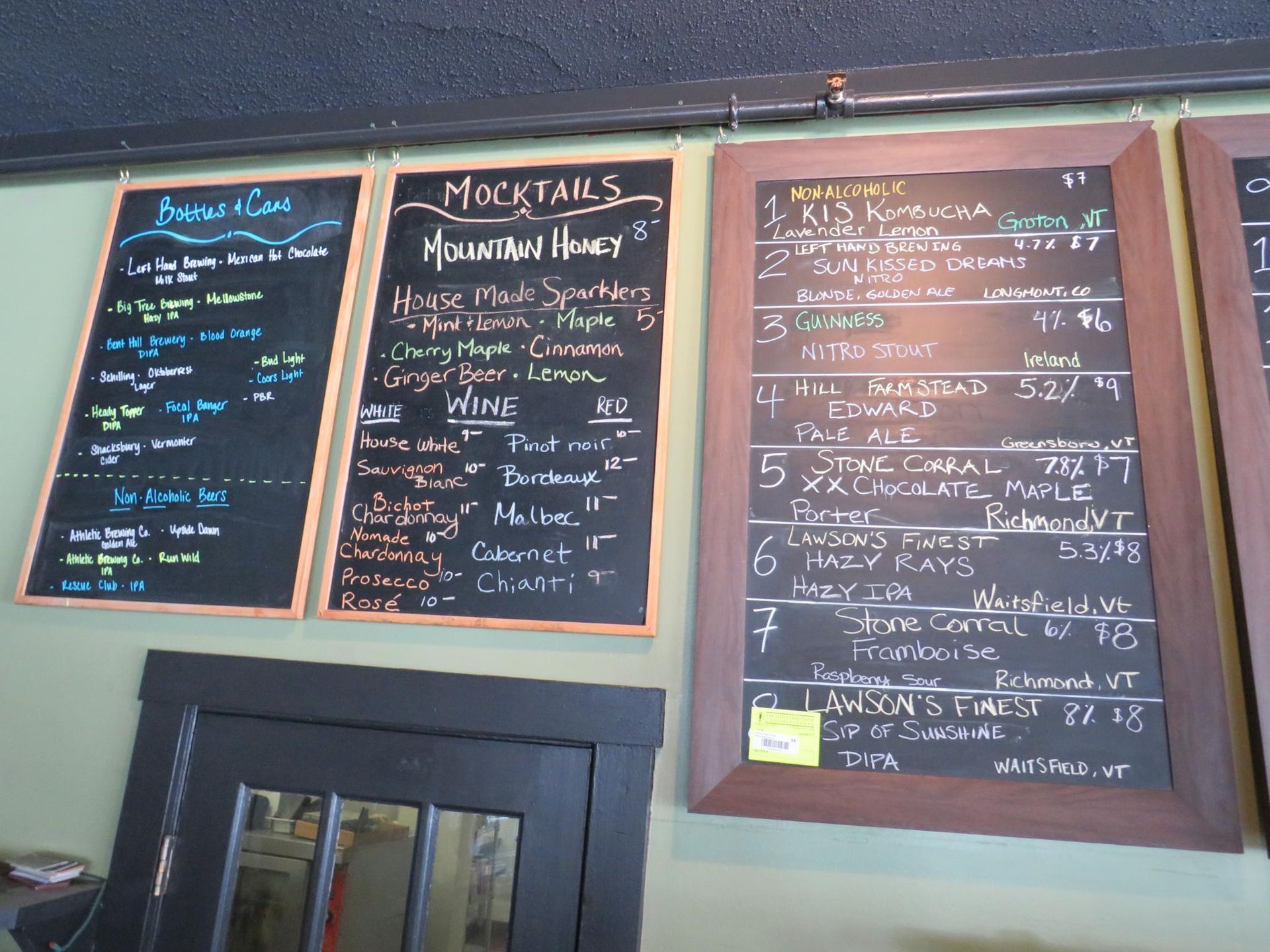 Chalkboard menus with drink selections, likely in a bar or restaurant setting.