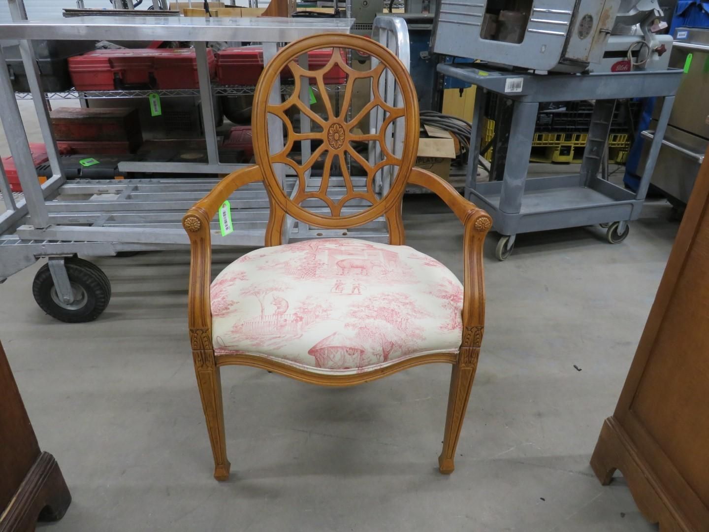 Wooden chair with a patterned cushion and open back in a workshop.