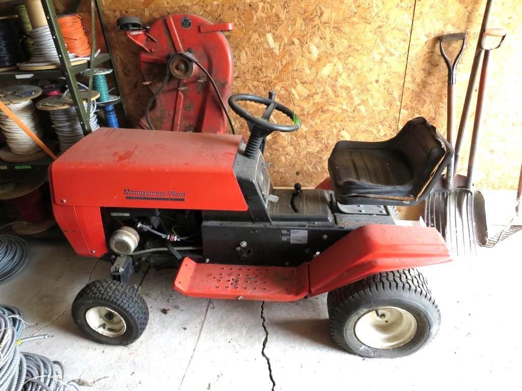 Red riding lawnmower parked in a garage.