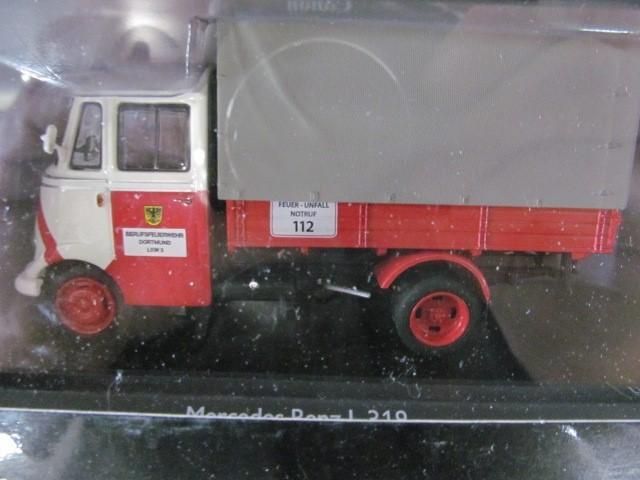 Model of a red and white Mercedes-Benz L 310 truck with a gray cover.