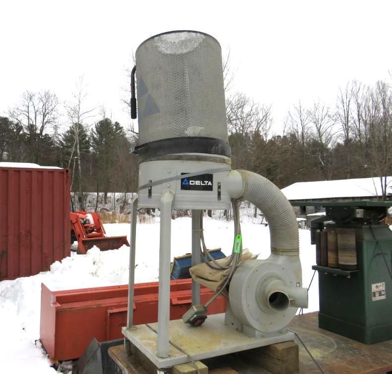 Delta dust collector machine outdoors on a snowy day.