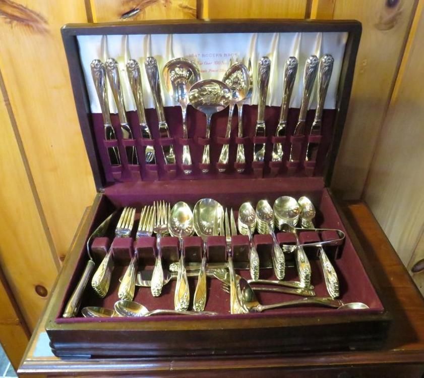 Silverware set in a wooden case, arranged on burgundy velvet.