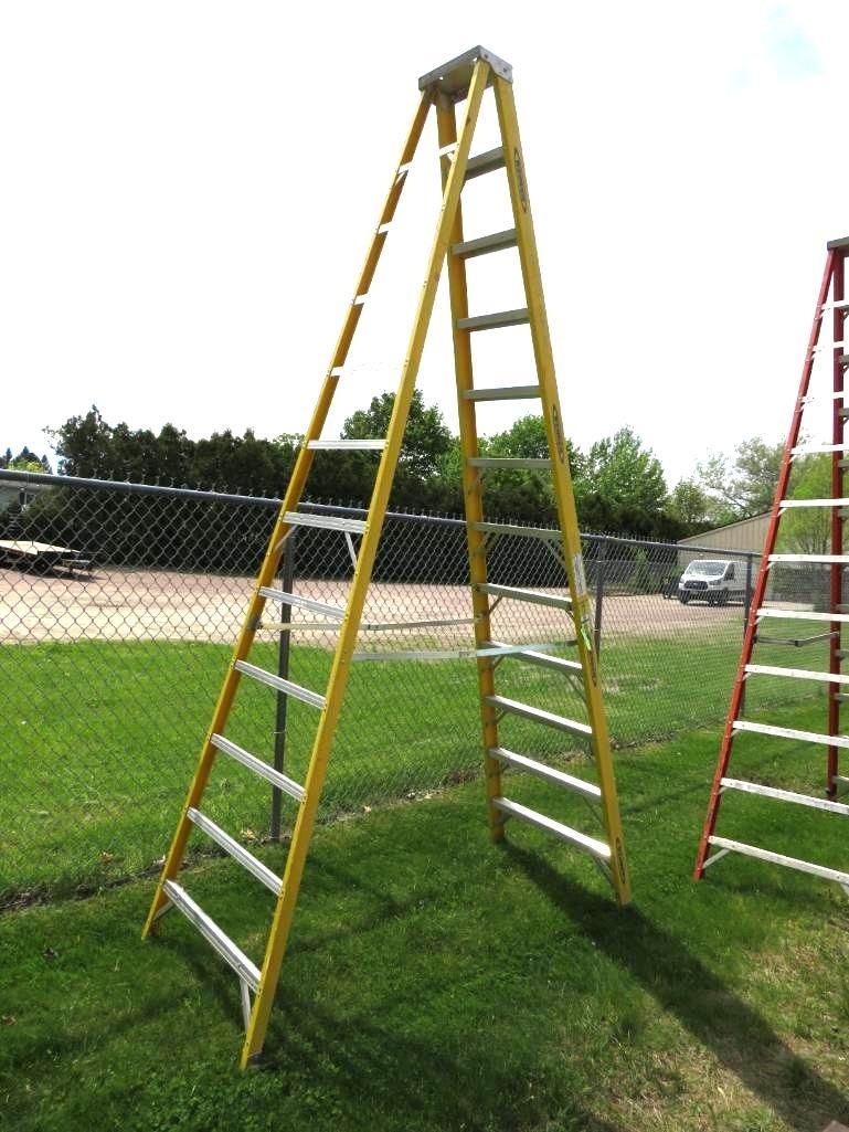 Yellow A-frame ladder on green grass.