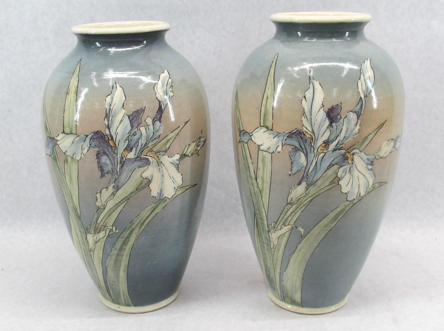 Two ceramic vases with painted iris flowers. Shades of blue, tan, and white.