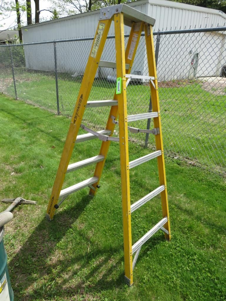 Yellow step ladder on green grass.