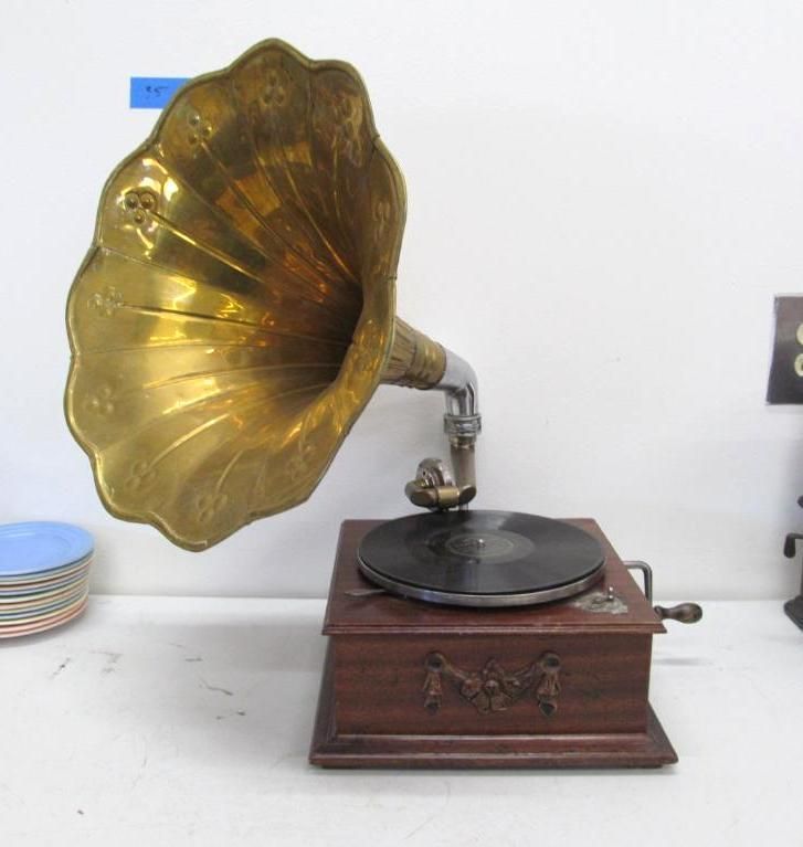 Antique gramophone with a brass horn, wooden box, and record on the turntable.
