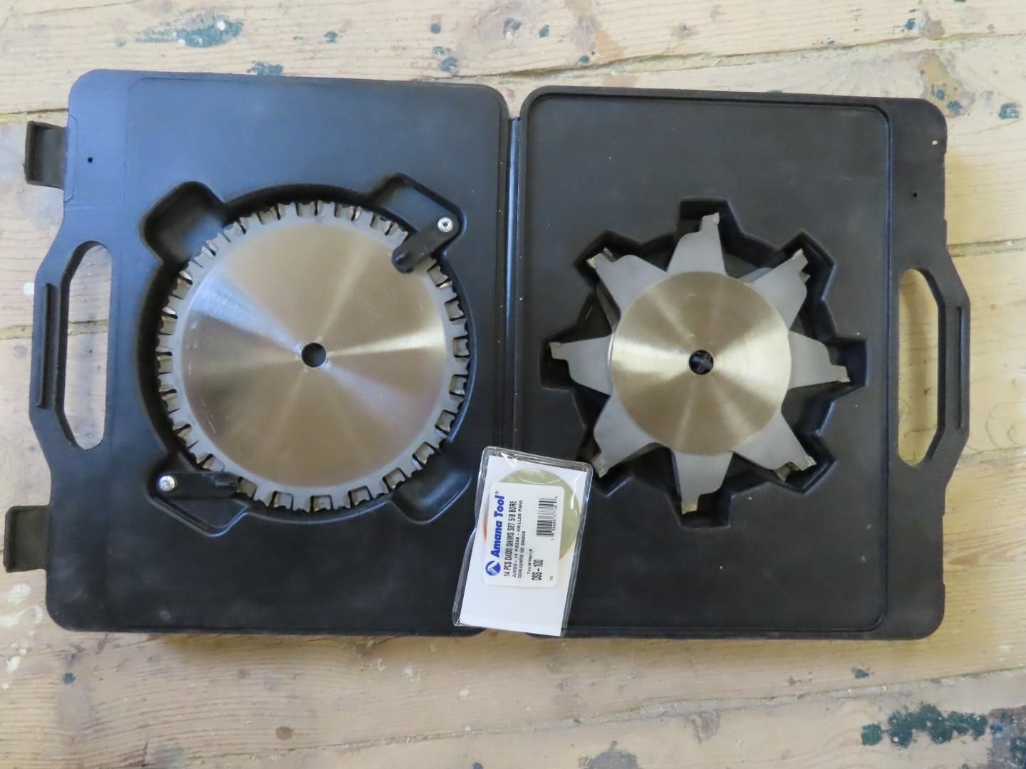 Two black plastic cases holding metal saw blades, side by side on a work surface.