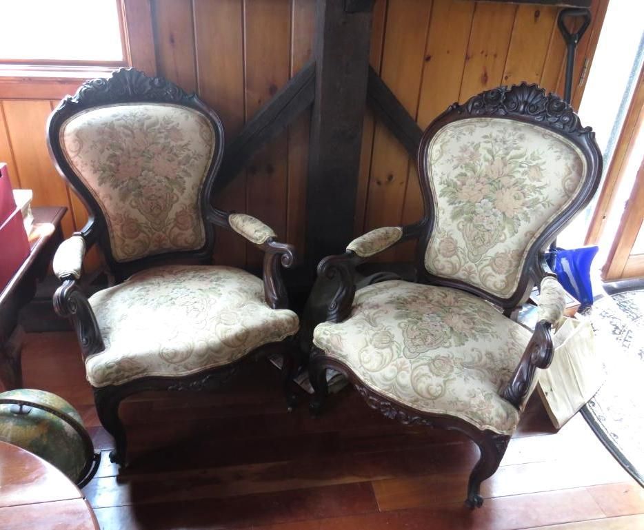 Two ornate dark wood chairs with floral patterned upholstery.