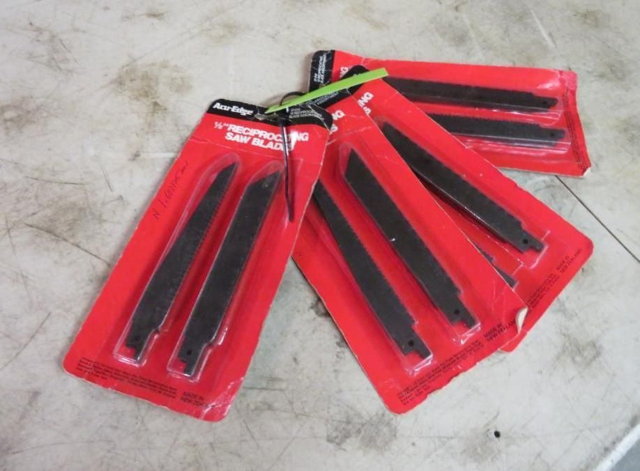 Several packages of reciprocating saw blades, red and black.