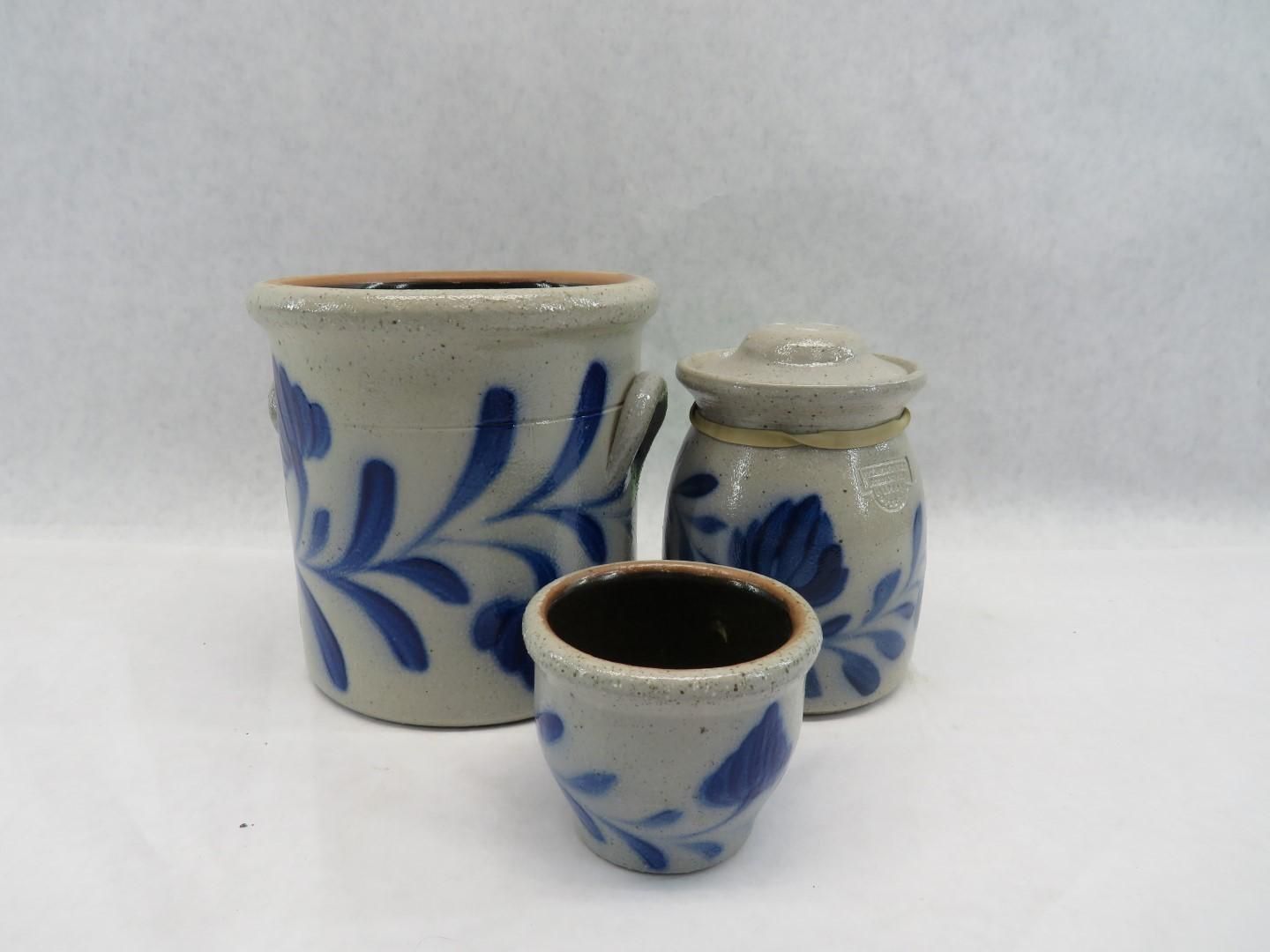 Three beige stoneware pots with blue floral designs: one large, one medium, and one small.