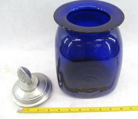Cobalt blue glass jar with metal lid, lid placed beside the jar, yellow measuring tape in front.