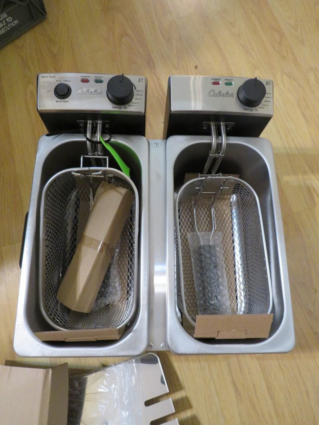 Two stainless steel deep fryers with baskets, controls, and accessories.