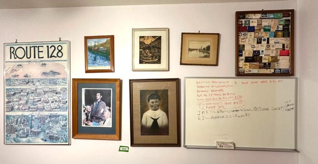 Wall with framed pictures: Route 128 sign, landscapes, portraits.
