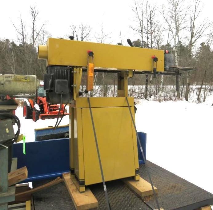 Yellow industrial machine on a trailer, strapped down.