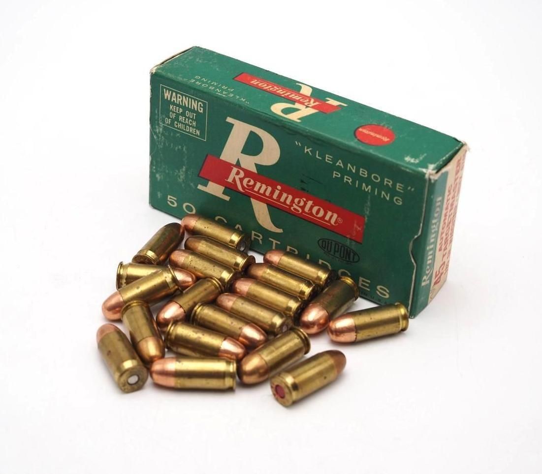 Green ammunition box with brass bullets spilled in front of it