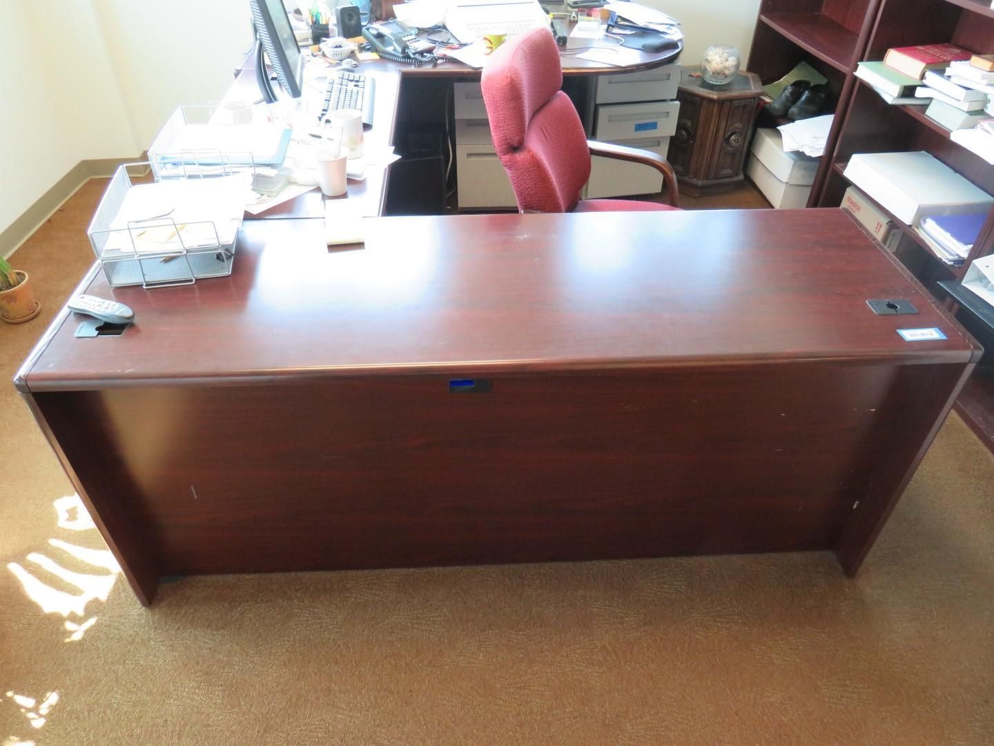 A dark wood office desk with a red chair.