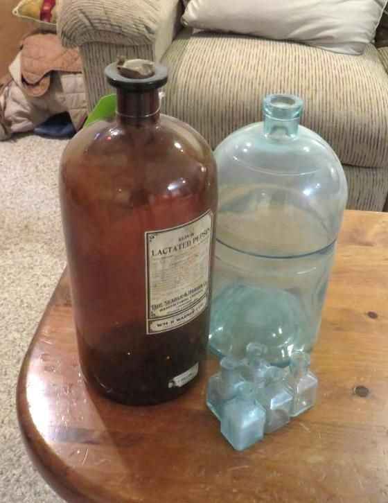 Brown and blue antique glass bottles on a wooden table.