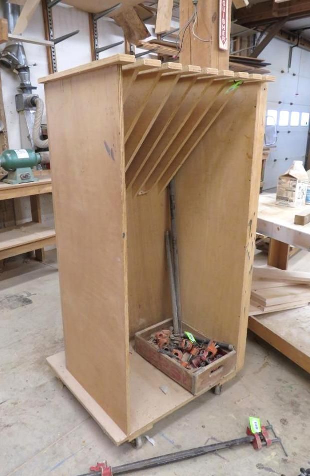 Wooden cabinet with angled shelves holding woodworking tools. A tray of tools sits inside.