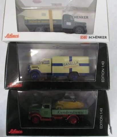 Three model trucks in boxes, each different color and design.