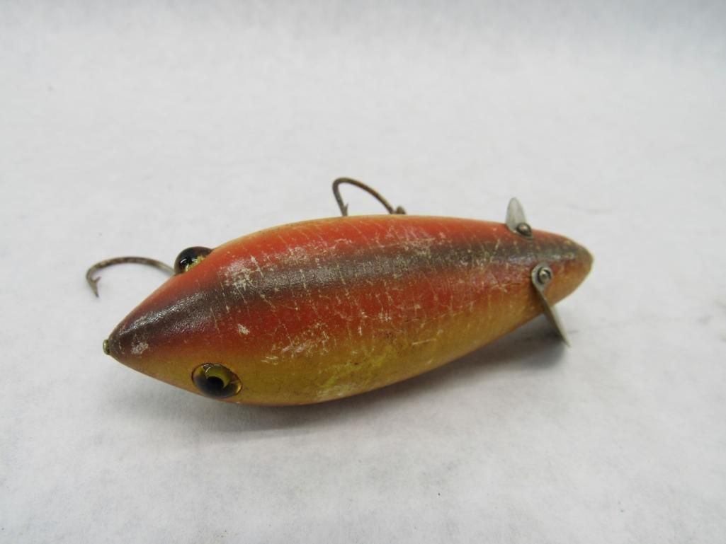 Orange and yellow fishing lure with two hooks and small propeller.