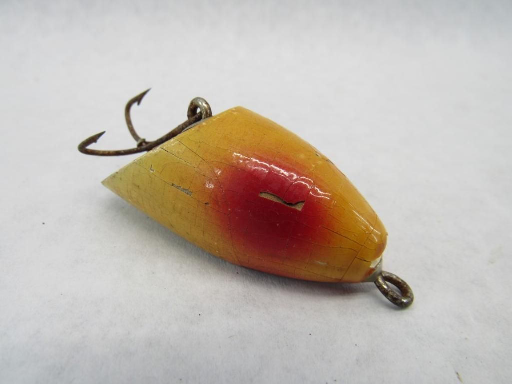 Yellow and red fishing lure with a treble hook.